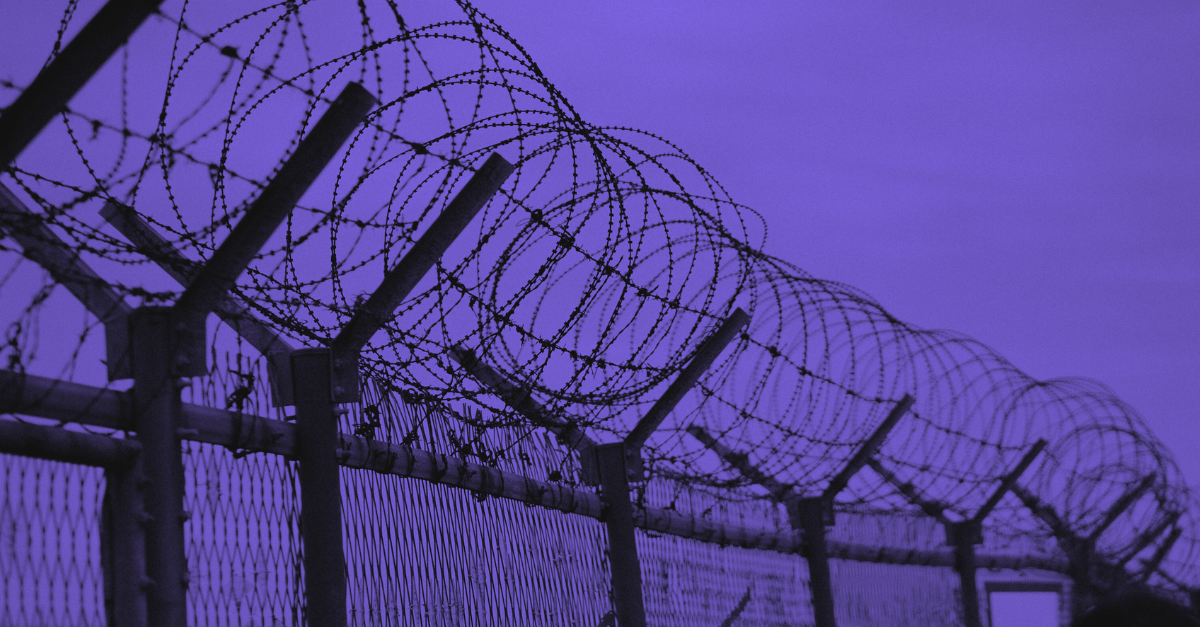 shot of upper part of fence with circular barbed wire on top