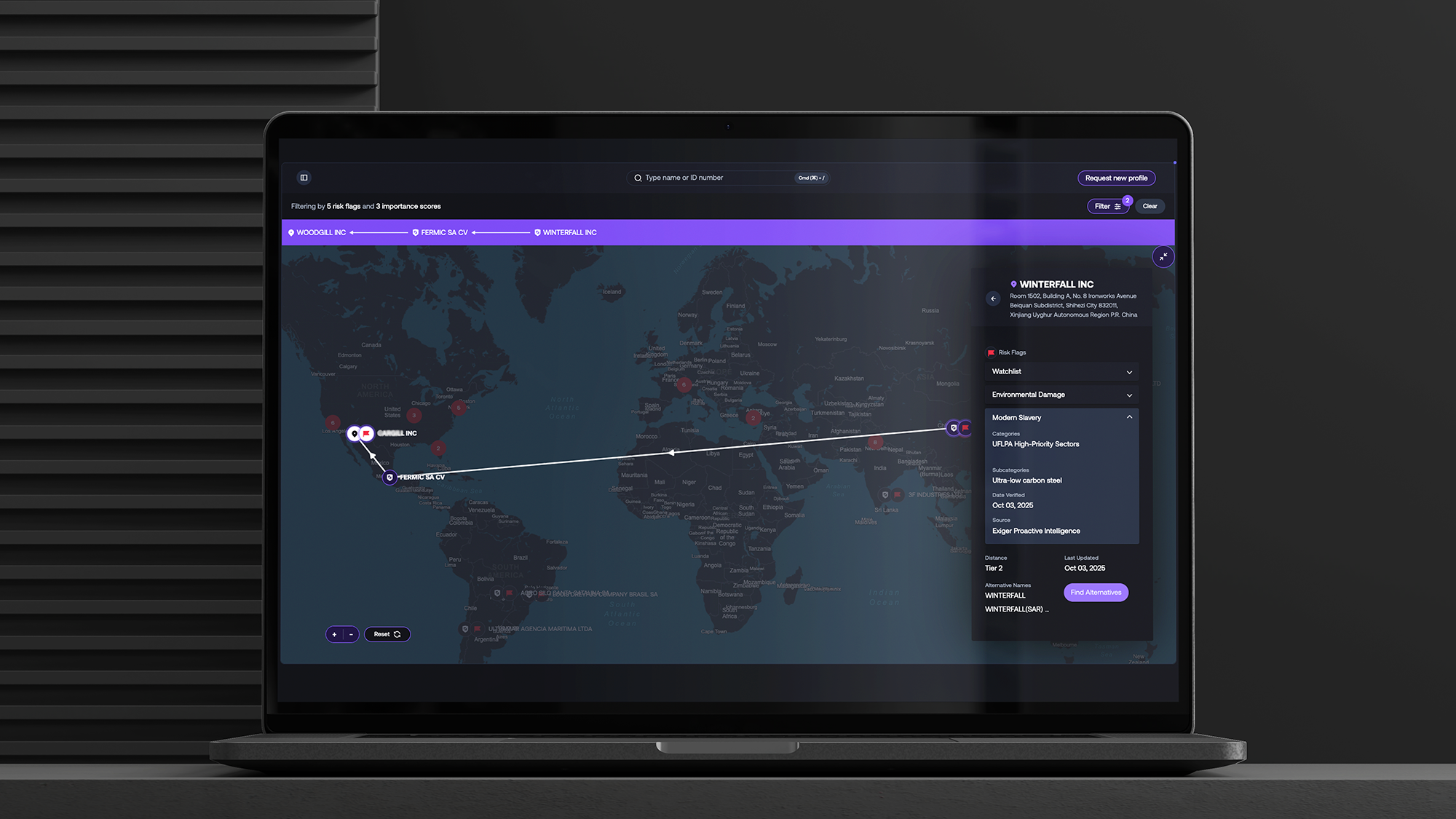 Laptop displaying the 1Exiger global supply chain risk intelligence platform, showing supplier connections from the U.S. to China with alerts for environmental damage and modern slavery risks.